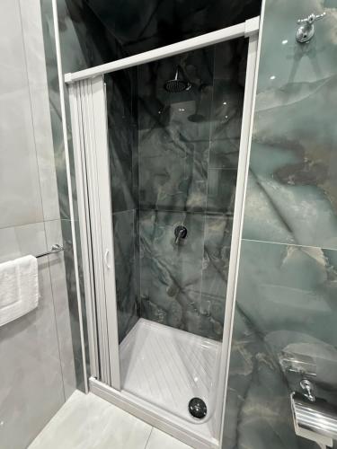 a shower with a glass door in a bathroom at Palazzo Valentino in Naples