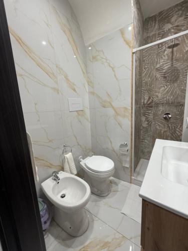 a white bathroom with a toilet and a sink at Palazzo Valentino in Naples