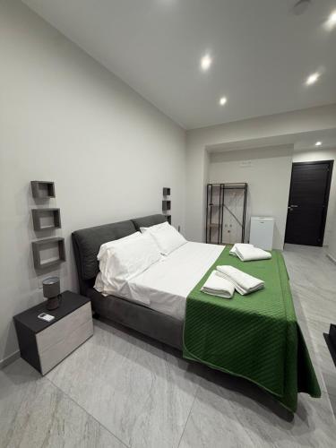 a bedroom with a large bed with a green blanket at Palazzo Valentino in Naples