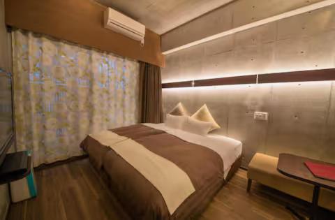 a bedroom with a large bed and a desk and a bed sidx sidx at Condominio Makishi Annesso in Naha
