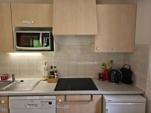 une cuisine avec un micro-ondes et une cuisinière four supérieur dans l'établissement Cocooning apartment- 2 personnes - FR-1-198-221, à Châtel