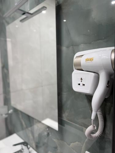 a hair dryer hanging on a wall in a bathroom at Palazzo Valentino in Naples