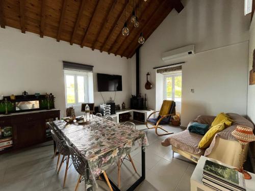 ein Wohnzimmer mit Tisch und Couch in der Unterkunft Green Sunrise House in Nordeste