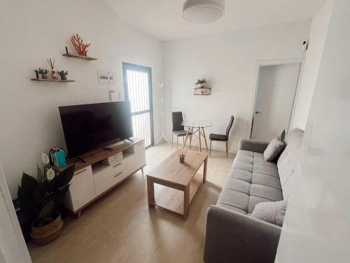 a living room with a couch and a flat screen tv at Apartamento patio Andaluz in Rota