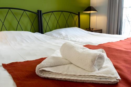 a white towel sitting on top of a bed at RentRooms Thessaloniki in Thessaloniki
