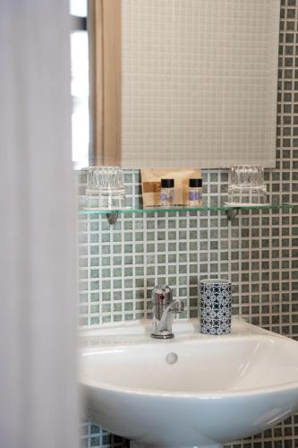 a white sink in a bathroom with a mirror at RentRooms Thessaloniki in Thessaloniki