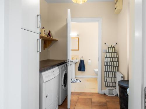 a kitchen with a washer and dryer and a bathroom at Cuirt Haven Clifden in Clifden