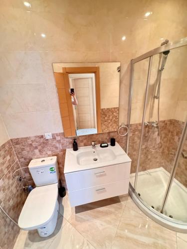 a bathroom with a toilet and a sink and a shower at Bright Apt with Balcony, WiFi, Parking and Pool Resort in Bouznika