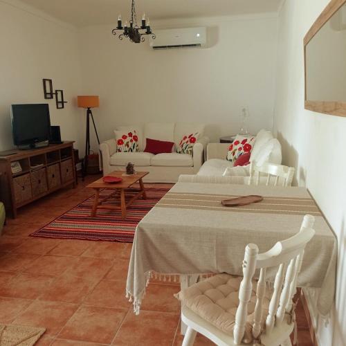 a living room with a table and a couch at Casa da Vila in Mourão