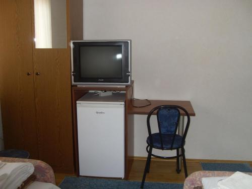 a tv sitting on top of a desk with a chair at Residence Krstanoski in Ohrid