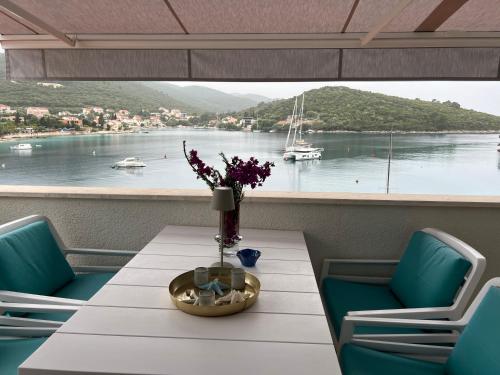 a table and chairs with a view of the water at Korcula Apartment direkt am Meer -Zrnovska banja -2,5 km zur Altstadt Korcula in Korčula
