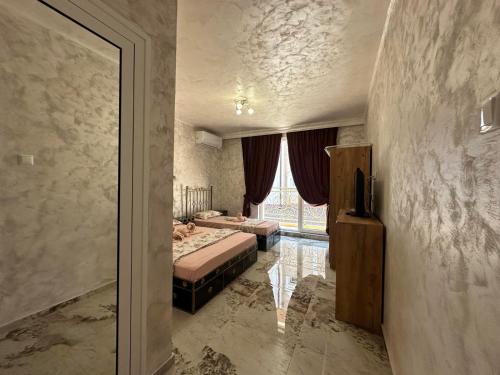 a hotel room with two beds and a window at Dracena Guesthouse in Ravda