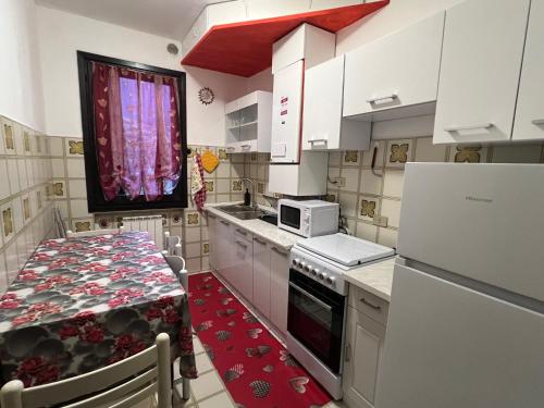 a kitchen with white cabinets and a table with a microwave at Al glicine in Lovere