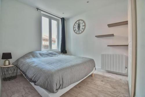 une chambre avec un lit et une horloge au mur dans l'établissement L'Etape, à Maintenon