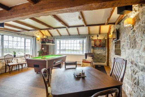 a living room with a table and a pool table at Ty Dderw Country Inn in Moelfre