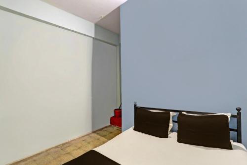 a bedroom with a bed with black pillows at SPOT ON 7 Day Stay in Chandrapur
