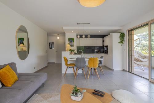 een woonkamer met een bank en een tafel bij Tournette, vue montagne & belle terrasse in Annecy