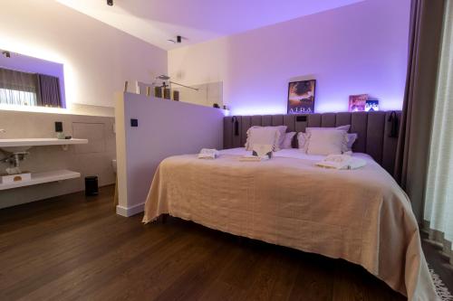 a bedroom with a large bed with purple lighting at Hof van In & Wellness in Hasselt