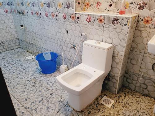 a bathroom with a toilet in a tiled room at Kisimani Heights one bedrrom with two beds in Mombasa