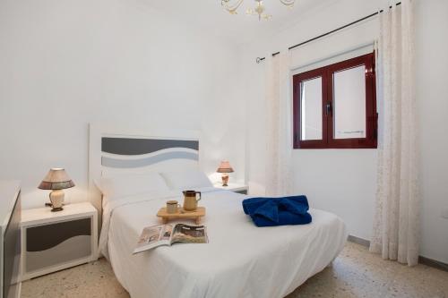 a white bedroom with a bed and a tv at Casa Abuela Maruca in Corralejo