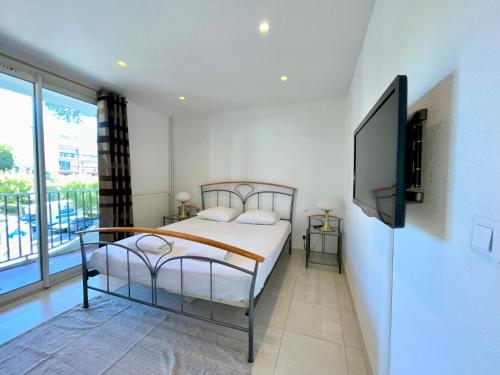 une chambre avec un lit et une télévision à écran plat dans l'établissement PGH N38 - Centre-Ville, Port avec Parking Privé, à La Grande Motte