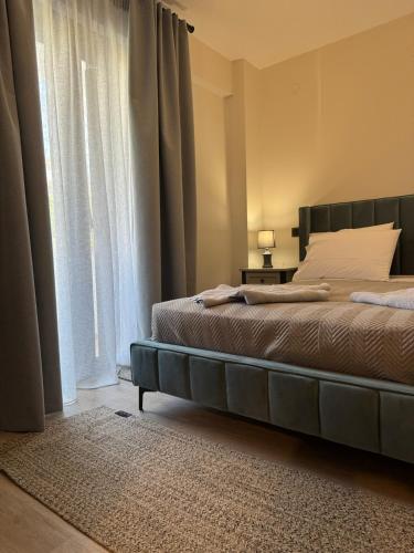 a bedroom with a bed and a large window at Apellou Apartments in Vathý