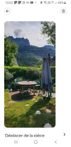 une photo d'une table et d'un parasol dans l'établissement Echarvines, à Talloires