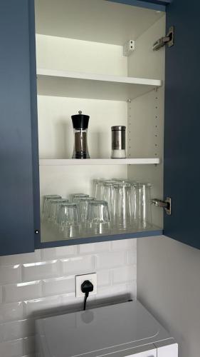 a kitchen with a shelf with glasses on it at Ayla Aqaba Azure 2 bedroom 0922 in Aqaba