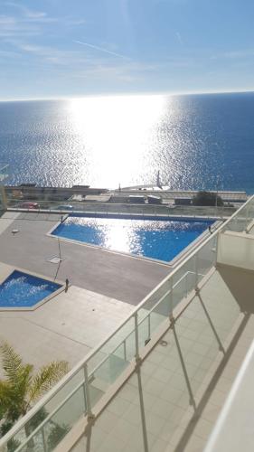 a view of a swimming pool with the ocean in the background at Pearl Sesimbra in Sesimbra