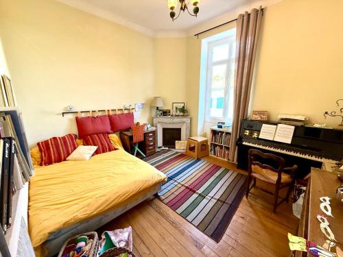 une chambre avec un lit et un piano dans l'établissement Les Arènes de Cimiez, à Nice