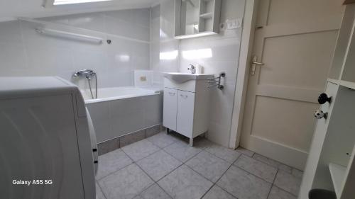 a white bathroom with a sink and a tub and a shower at Downtown Dream Makarska in Makarska