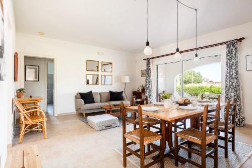 a dining room and living room with a table and chairs at New! Villa Margarita - Menorca in Punta Prima