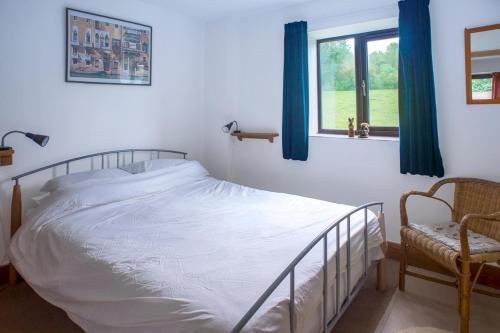 a bedroom with a bed and a window and a chair at Accessible Barn 4 Bedrooms Farm stay sleeps 8 in Mayfield