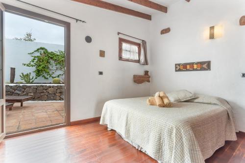 a bedroom with a bed and a large sliding glass door at Casa Rural La Molina in Máguez
