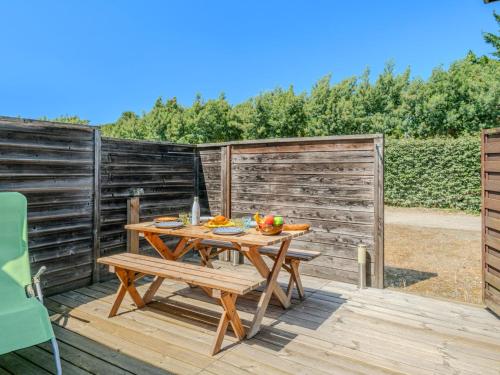 une table et un banc en bois sur une terrasse en bois dans l'établissement Apartment Les Malgaches-2 by Interhome, à Mimizan