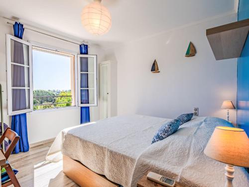une chambre blanche avec un lit et une fenêtre dans l'établissement Holiday Home Les Coralines by Interhome, aux Issambres