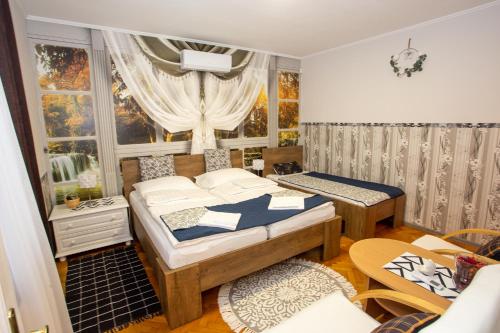 a bedroom with two beds and a window at Dio Apartmanok in Balatonboglár
