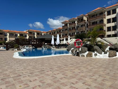 a swimming pool in front of a hotel at Ocean View Tenerife South Coast in Costa Del Silencio