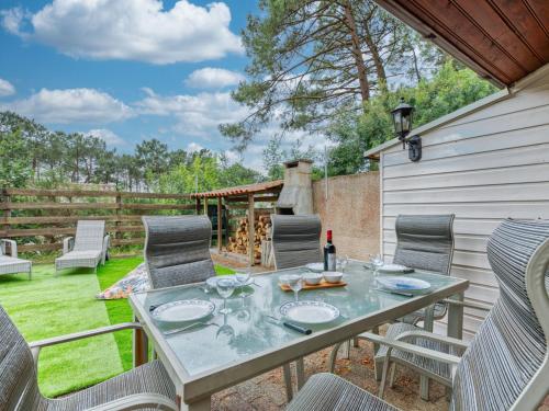 un patio avec une table et des chaises dans une cour dans l'établissement Holiday Home Les Cracks - Les As-11 by Interhome, à Lacanau