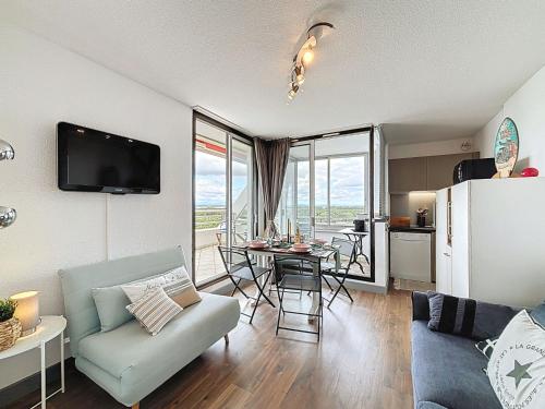 un salon avec un canapé et une table avec des chaises dans l'établissement Apartment Les Marquises-2 by Interhome, à La Grande Motte