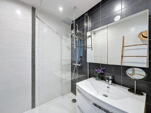 une salle de bain blanche avec un lavabo et une douche dans l'établissement Apartment Les Marquises-2 by Interhome, à La Grande Motte