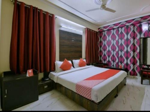 a bedroom with a bed with red curtains at Hotel Sky high in Jaipur