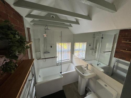 une salle de bain avec un lavabo, des toilettes et une baignoire dans l'établissement Hill View Cottage, à Mappleton