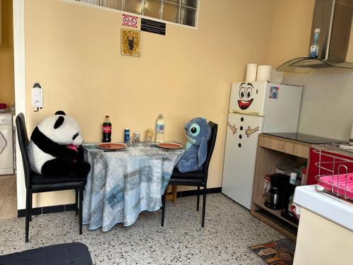 a kitchen with a table with a panda bear sitting at it at CALME in Drancy
