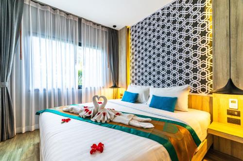 a bedroom with a bed with two swans on it at Antiya Hotel Phuket in Phuket Town