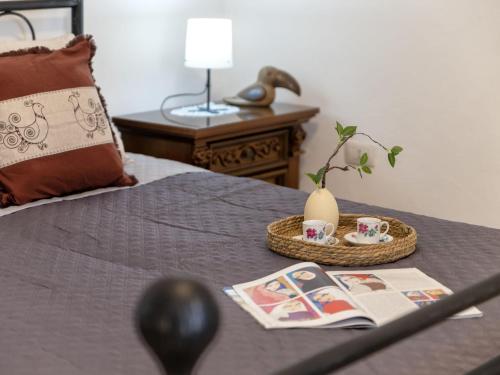 a bed with a table with a tray with a basket with tea cups at Apartment Sos Candhaleris by Interhome in Nulvi