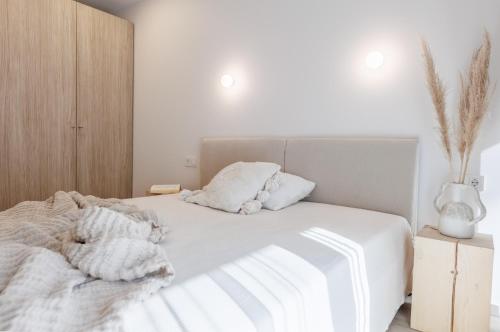a bedroom with a white bed with white sheets and pillows at Nidos Banga in Nida