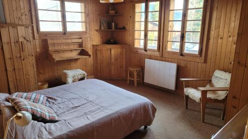 une chambre avec un lit, une chaise et des fenêtres dans l'établissement Les Valamonts, à Saint-Gervais-les-Bains