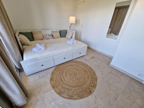 - un lit blanc dans une chambre avec un tapis dans l'établissement Studio Le Floriana-2 by Interhome, à Cannes