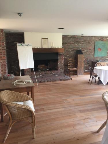 a room with a table and chairs and a fireplace at De Mankemerrie in Tielt
